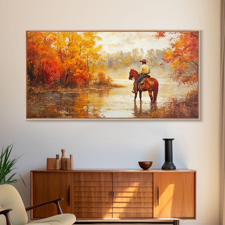 Cowboy sitting by campfire near a lake in the woods with autumn leaves, Framed Canvas Print, moody fall wall art, rustic western home decor